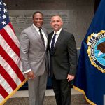 Delray Beach Police Assistant Chief Anthony Martinez Standing Beside An Fbi National Academy Flag After Graduating From Session 298.