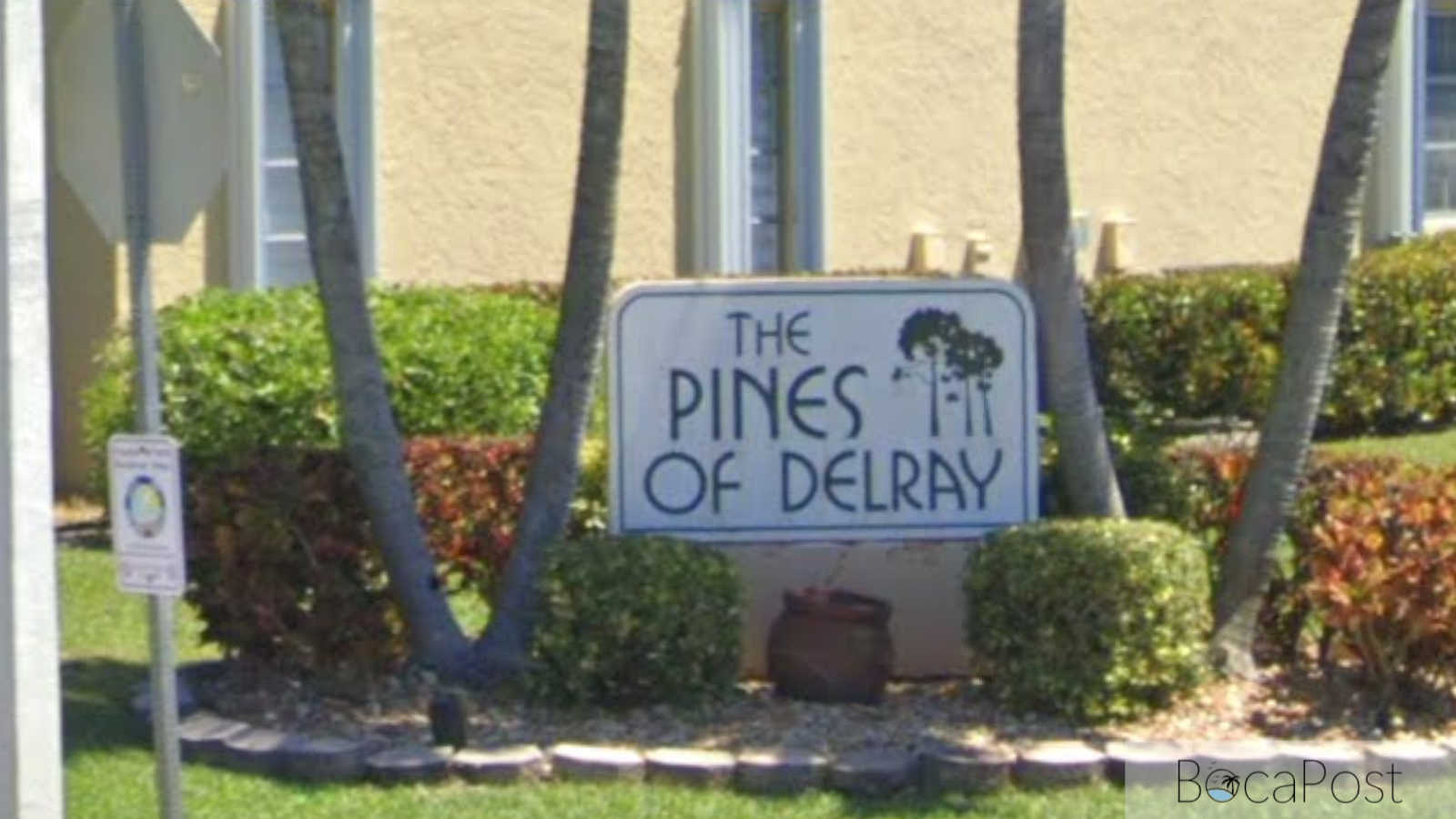 Entrance sign and gated entry to the Pines of Delray condominium community in Delray Beach, Florida.