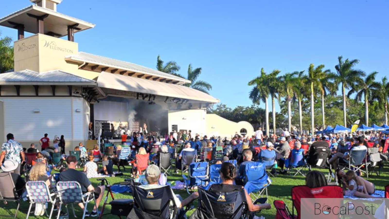 Audience seated on the lawn at Wellington Amphitheater during a live concert.