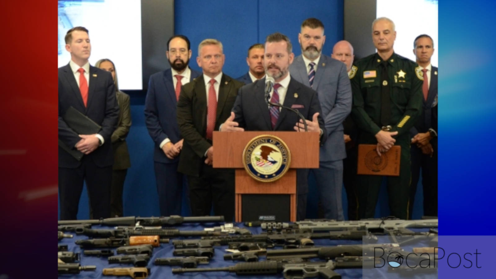 U.S. Attorney Jason A. Reding Quiñones speaks at a podium with federal and local law enforcement officials behind him.