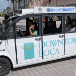 A White And Green Circuit Electric Shuttle Marked Bocaconnect Parked In Boca Raton.