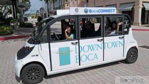 A White And Green Circuit Electric Shuttle Marked Bocaconnect Parked In Boca Raton.