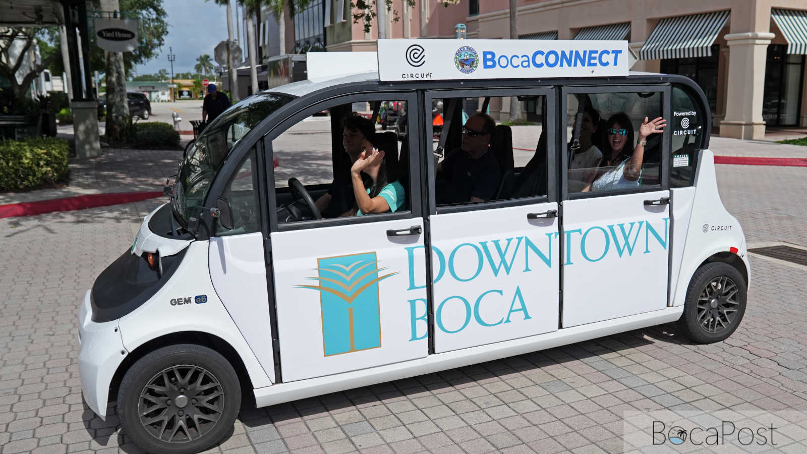 A white and green Circuit electric shuttle marked BocaConnect parked in Boca Raton.