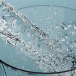 Clear Tap Water Filling A Drinking Glass At A Kitchen Sink.