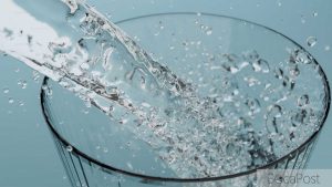 Clear Tap Water Filling A Drinking Glass At A Kitchen Sink.