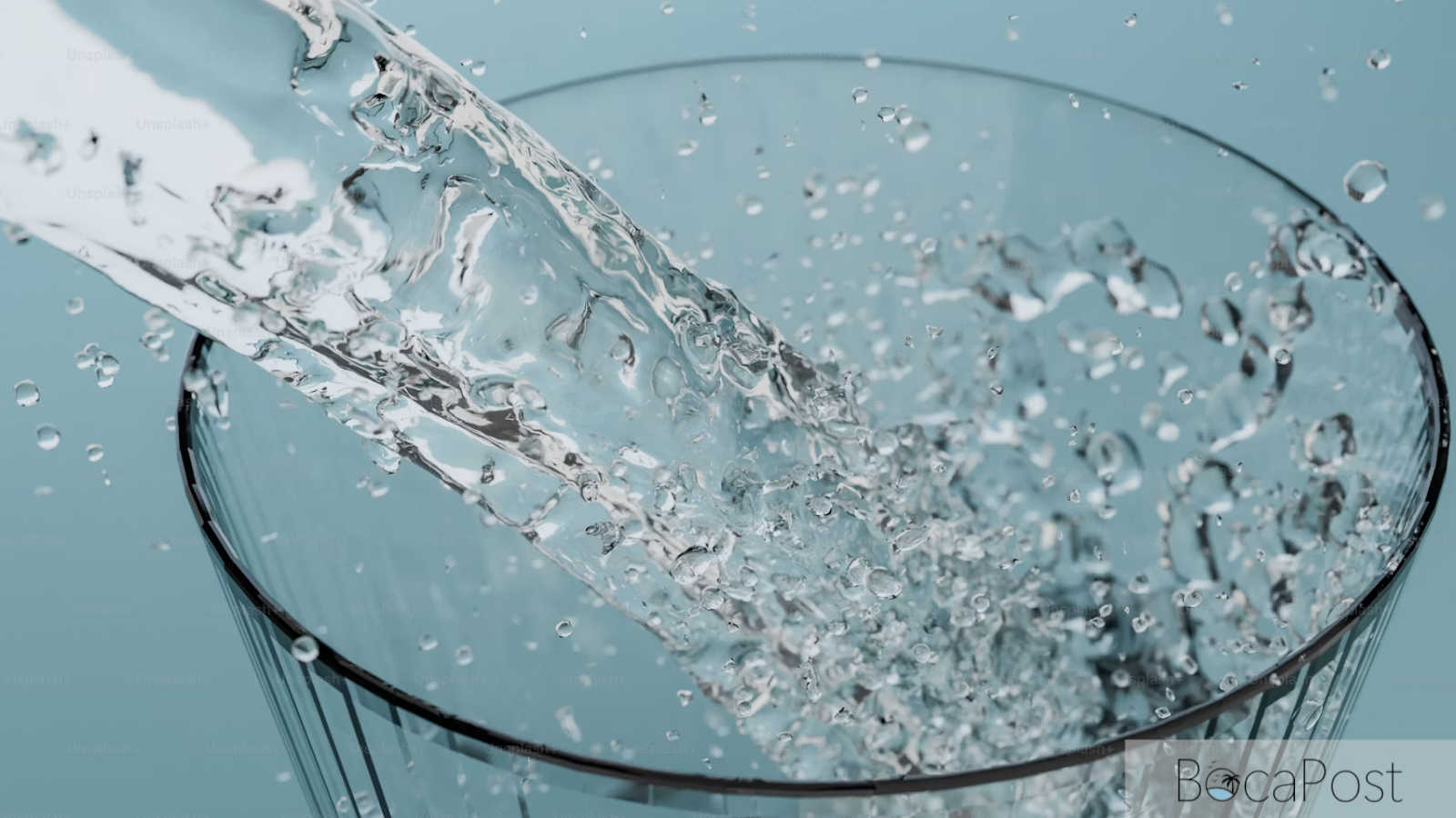 Clear tap water filling a drinking glass at a kitchen sink.